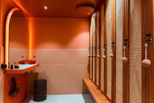 uma casa de banho com paredes cor-de-laranja e uma cabina de duche ao nível do chão em Näsby Slott em Täby