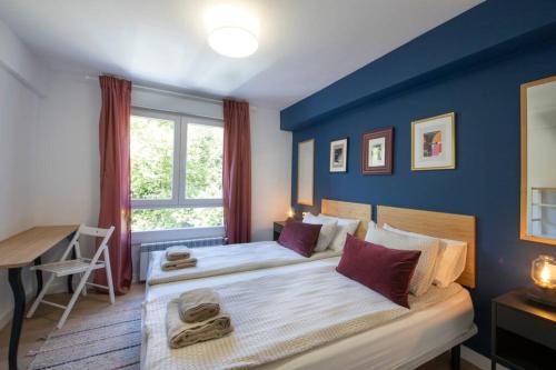 - une chambre avec 2 lits et un mur bleu dans l'établissement ACOGEDOR APARTAMENTO a 10 MINUTOS de la CIUDAD, à Rentería