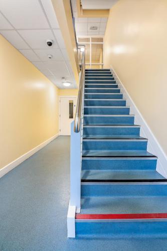 a staircase in an office building with blue and red carpet at Clarion Village in Sligo