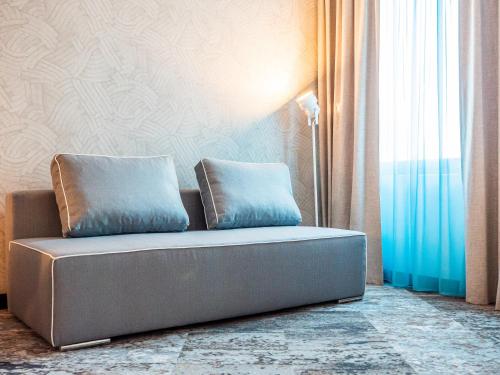 a couch with two pillows on it in a room at Fletcher Hotel-Restaurant Scheveningen in Scheveningen