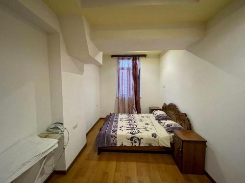 um pequeno quarto com uma cama e uma janela em Apartment in Abovyan Street, Yerevan em Yerevan