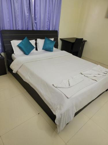 a bedroom with a large bed with blue pillows at The Royal Luxury Stay in Pune