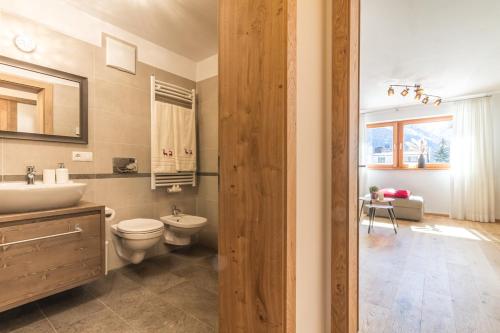 ein Bad mit einem WC und einem Waschbecken in der Unterkunft HAUS GREG in Toblach