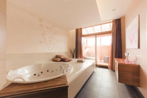 a large bathroom with a large tub in a room at Terme Zreče – Hotel Atrij in Zreče