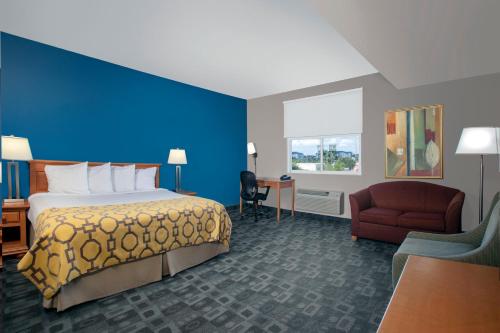 Pokój hotelowy z łóżkiem i niebieską ścianą w obiekcie Baymont by Wyndham Miami Doral w Miami