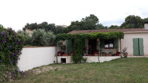 a small white house with a green door at L'Olivette in Montfrin