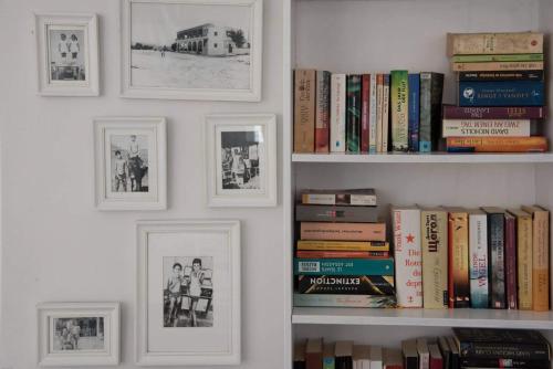 une étagère avec des livres et des photos sur un mur dans l'établissement Fisilanis Beachfront Hotel, à Logaras