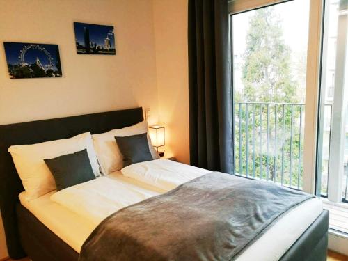 a bedroom with a bed with a large window at Cosy Park Apartment City Center in Vienna