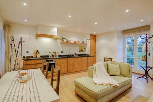 une cuisine et un salon avec un canapé et une table dans l'établissement Le Petit Tertre - charmante maison entre terre et mer - St Lunaire, à Saint-Lunaire