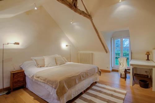 a bedroom with a large bed and a desk at Le Petit Tertre - charmante maison entre terre et mer - St Lunaire in Saint-Lunaire