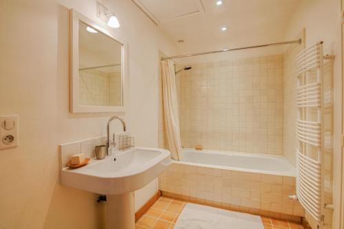 La salle de bains est pourvue d'un lavabo et d'une baignoire. dans l'établissement Le Petit Tertre - charmante maison entre terre et mer - St Lunaire, à Saint-Lunaire