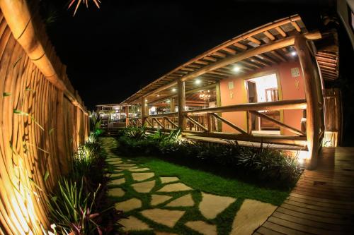 a walkway next to a building at night at Carapitangui Pousada in Barra Grande