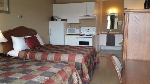 a small room with two beds and a kitchen at Motel Iberville in Saint-Jean-sur-Richelieu