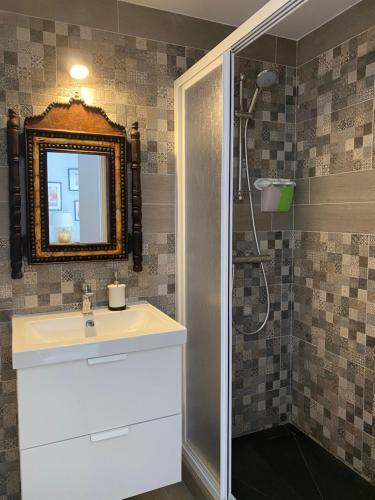 a bathroom with a sink, mirror, and bathtub at Hostal El Caprichito Marbella in Marbella