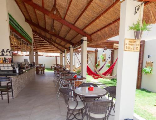 a restaurant with tables and chairs and a bar at Pousada Villa Goyá in São José da Coroa Grande
