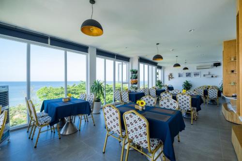 a restaurant with blue tables and chairs and windows at Brenta Phu Quoc Hotel in Phu Quoc