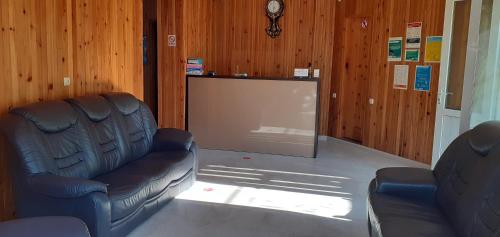 a cinema room with two leather chairs and a screen at Villa Ureki in Ureki