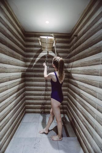 a woman is standing in a room with a bucket at Bacolux Diana, Herculane in Băile Herculane