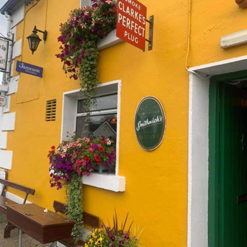 a yellow building with a window with flowers on it at Relaxing Break at Coshel View in Foyle Bridge