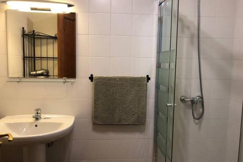 Un baño con lavabo y ducha de cristal. en The Penthouse Ascona in El Charco, en Arrecife