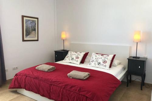 Un dormitorio con una cama roja y blanca con dos lámparas. en The Penthouse Ascona in El Charco, en Arrecife