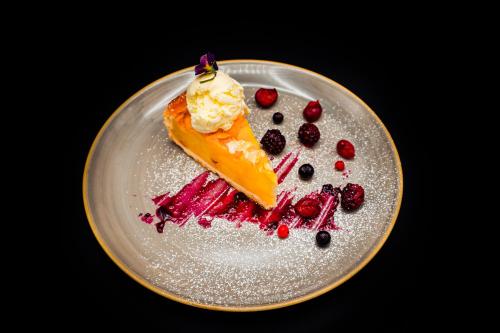 a plate with a piece of cake and berries at Bacolux Afrodita, Herculane in Băile Herculane