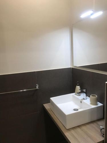 a bathroom with a white sink and a mirror at Sistra in Catania
