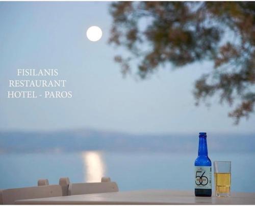 a bottle of wine and two glasses on a table at Fisilanis Beachfront Hotel in Logaras