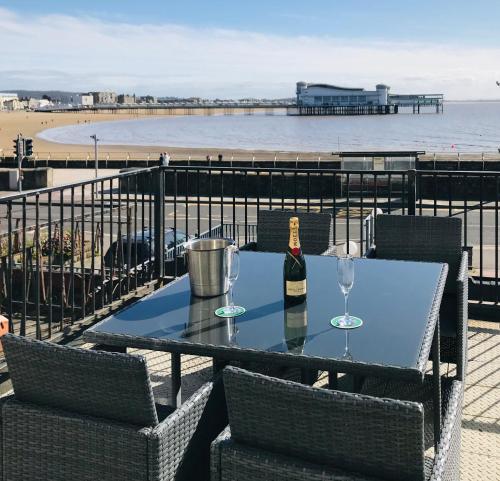 a table with a bottle of wine and two glasses at Pavilion Holiday Apartments in Weston-super-Mare