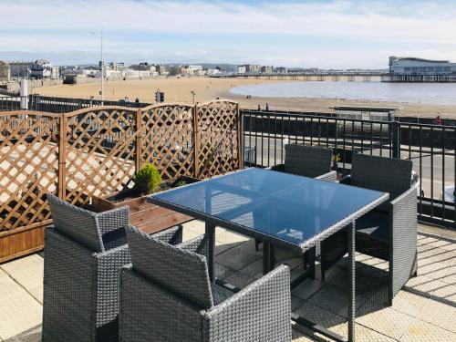 a table and chairs on a balcony with a beach at Pavilion Holiday Apartments in Weston-super-Mare