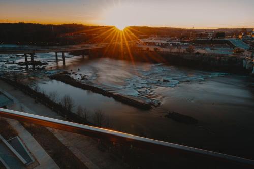 a view of a river at sunset with the sun setting at Hotel Indigo - Columbus at Riverfront Place by IHG in Columbus