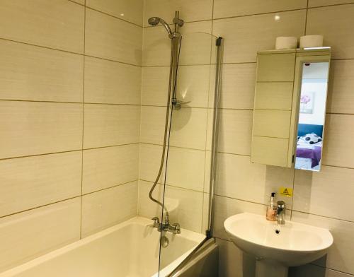 a bathroom with a tub and a sink and a shower at Pavilion Holiday Apartments in Weston-super-Mare