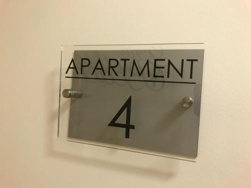 a sign that says apartment four on a wall at Pavilion Holiday Apartments in Weston-super-Mare