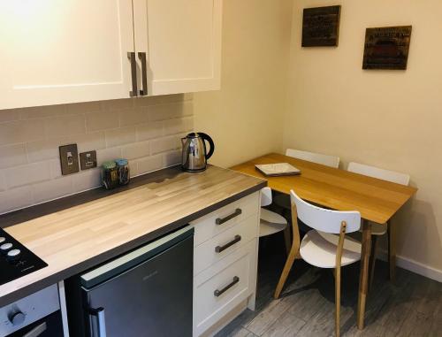 a small kitchen with a wooden counter top and a table at Pavilion Holiday Apartments in Weston-super-Mare