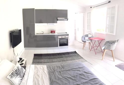 a living room with a kitchen with a stove at Studio at Boucan Canot 900 m away from the beach with enclosed garden and wifi in Boucan Canot