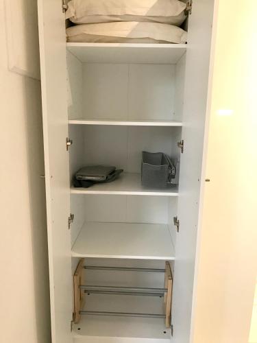 a walk in closet with white cabinets and shelves at Studio cosy à Boucan Canot, 30 m² avec jardin privé in Boucan Canot