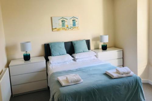a bedroom with a bed with two pillows on it at Pavilion Holiday Apartments in Weston-super-Mare