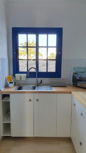 cocina con fregadero y ventana en Casa azul, en Playa Blanca