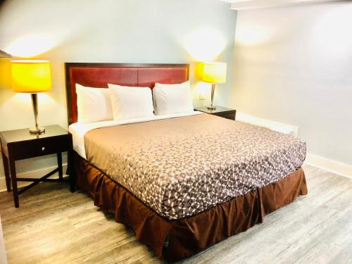 um quarto de hotel com uma cama e duas lâmpadas em Montgomery Inn & Suites em Montgomery