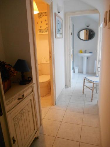 - un couloir avec une salle de bains pourvue de toilettes et d'un lavabo dans l'établissement Maison accueillante à Cléden-Cap-Sizun avec jardin clos, à Cléden-Cap-Sizun