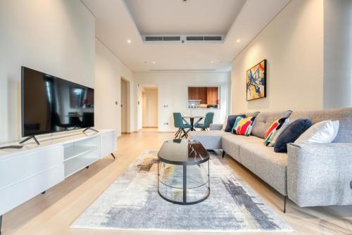 a living room with a couch and a tv at RH- Downtown Oasis, Spacious 01 BR in Downtown near Dubai Mall in Dubai