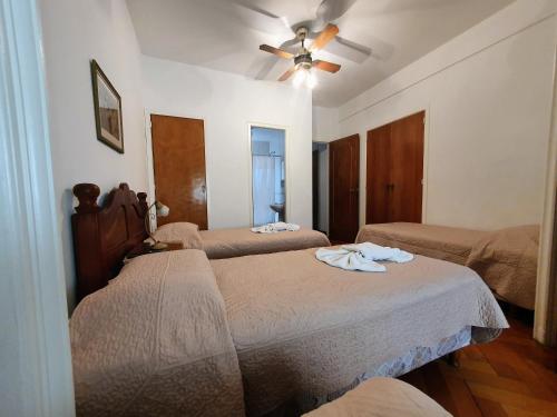 a bedroom with two beds and a ceiling fan at Administracion Callao in Buenos Aires