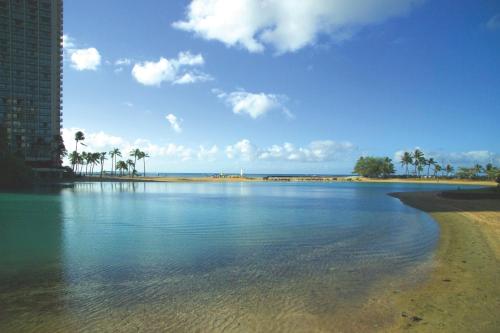 a body of water with a beach and a building at Waikiki Marina Resort at the Ilikai in Honolulu