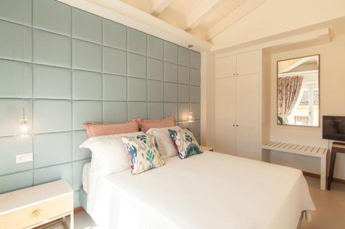 a bedroom with a white bed and a blue tiled wall at Villa Francesca Relais in Gradara