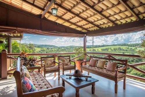 a living room with couches and a table on a balcony at Sítio Pandora - Interior de Minas por Carpediem in Pedro Leopoldo