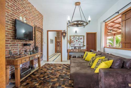 a living room with a couch and a brick wall at Sítio Pandora - Interior de Minas por Carpediem in Pedro Leopoldo