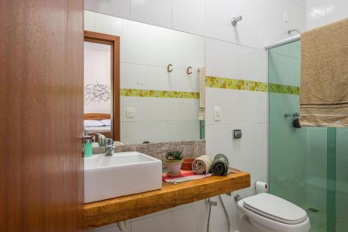 a bathroom with a sink and a toilet and a mirror at Sítio Pandora - Interior de Minas por Carpediem in Pedro Leopoldo