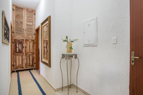 a hallway with a table with a vase on it at Sítio Pandora - Interior de Minas por Carpediem in Pedro Leopoldo