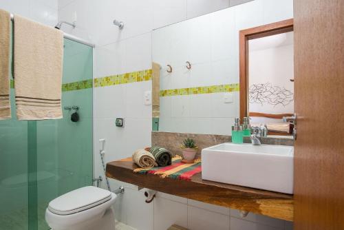 a bathroom with a sink and a toilet and a mirror at Sítio Pandora - Interior de Minas por Carpediem in Pedro Leopoldo