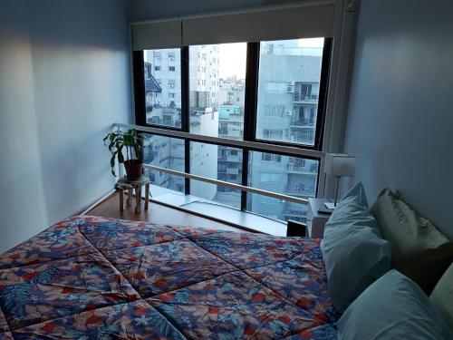 1 dormitorio con cama y ventana grande en Duplex Cabildo en Buenos Aires